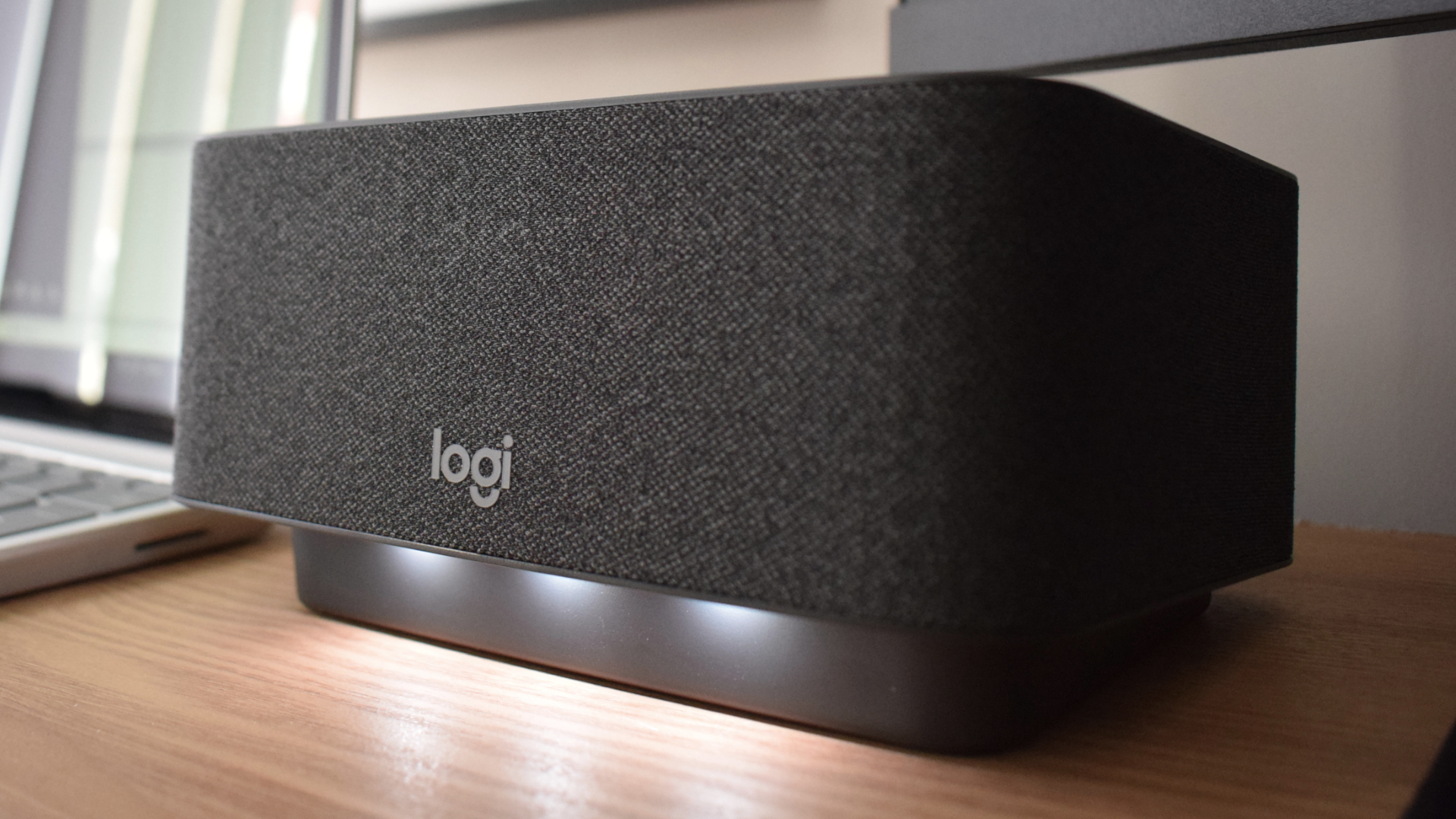 Photo of the Logitech Logi Dock docking station at an angle, showing the LED status lights positioned below its speaker.