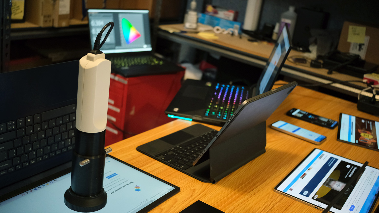 Three open and powered on laptops in view at the Laptop Mag testing lab.