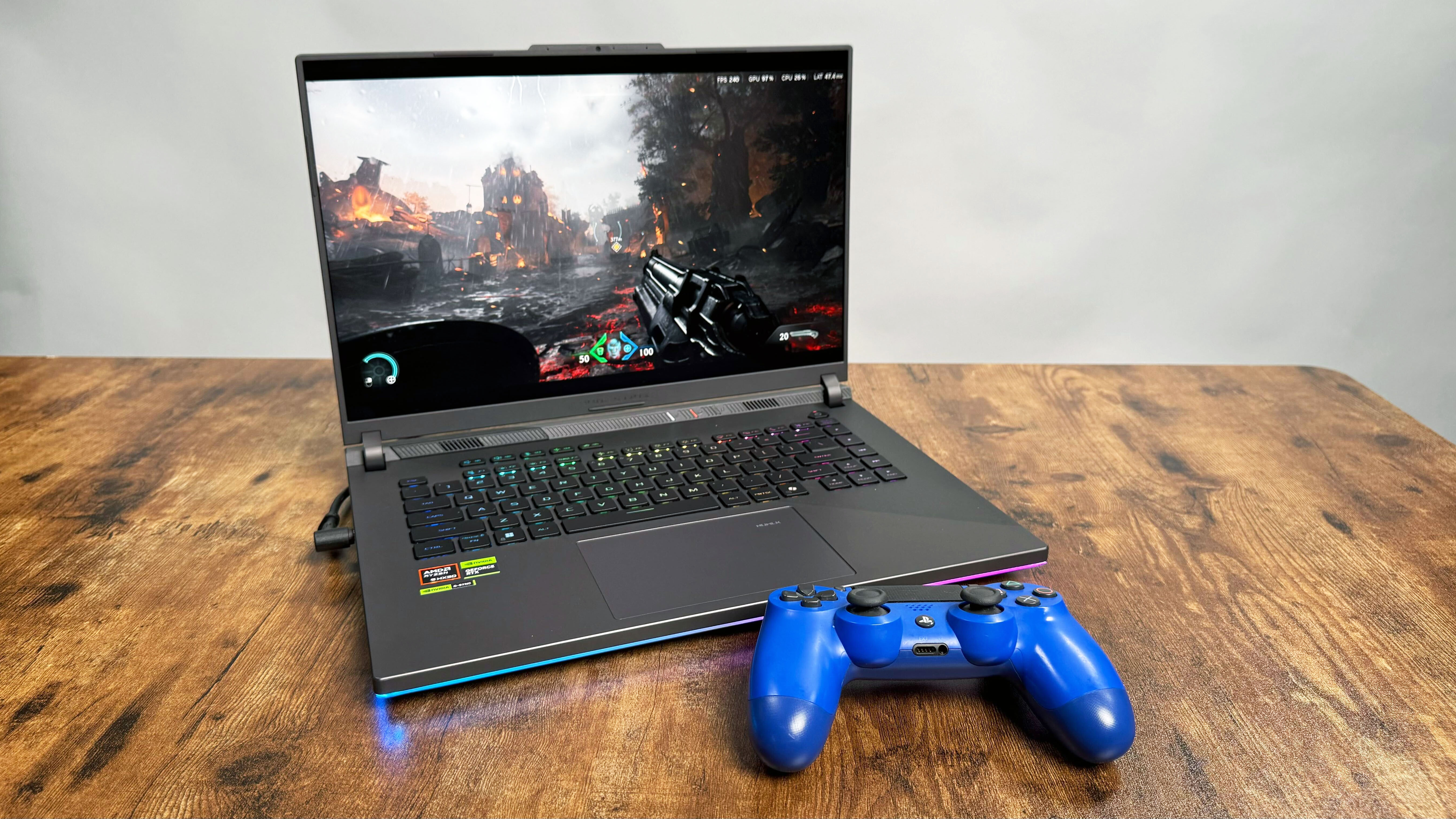 Asus ROG Strix G16 (G614FR) gaming laptop on a wooden desk against a gray background.
