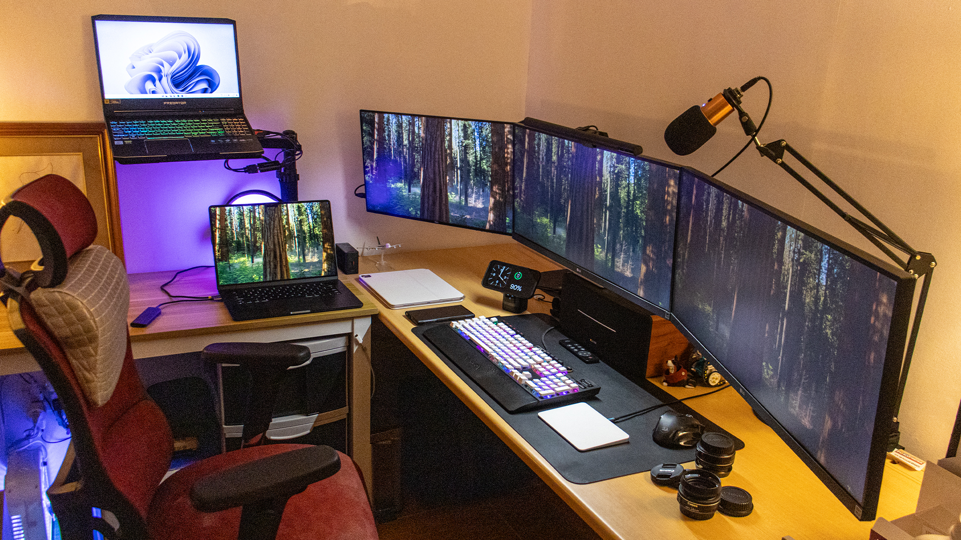 A triple-monitor work setup with a MacBook and Windows laptop.