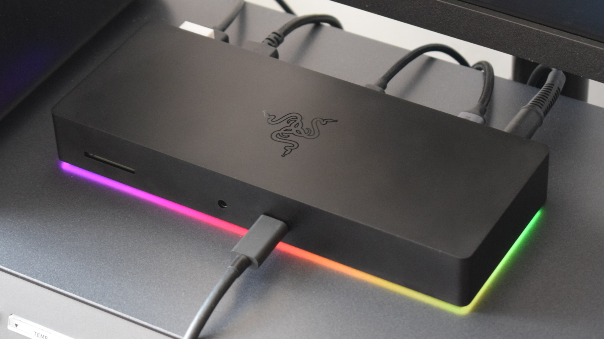 Photo of the Razer Thunderbolt 4 Dock Chroma docking station with RGB lighting enabled, while connected to various devices.