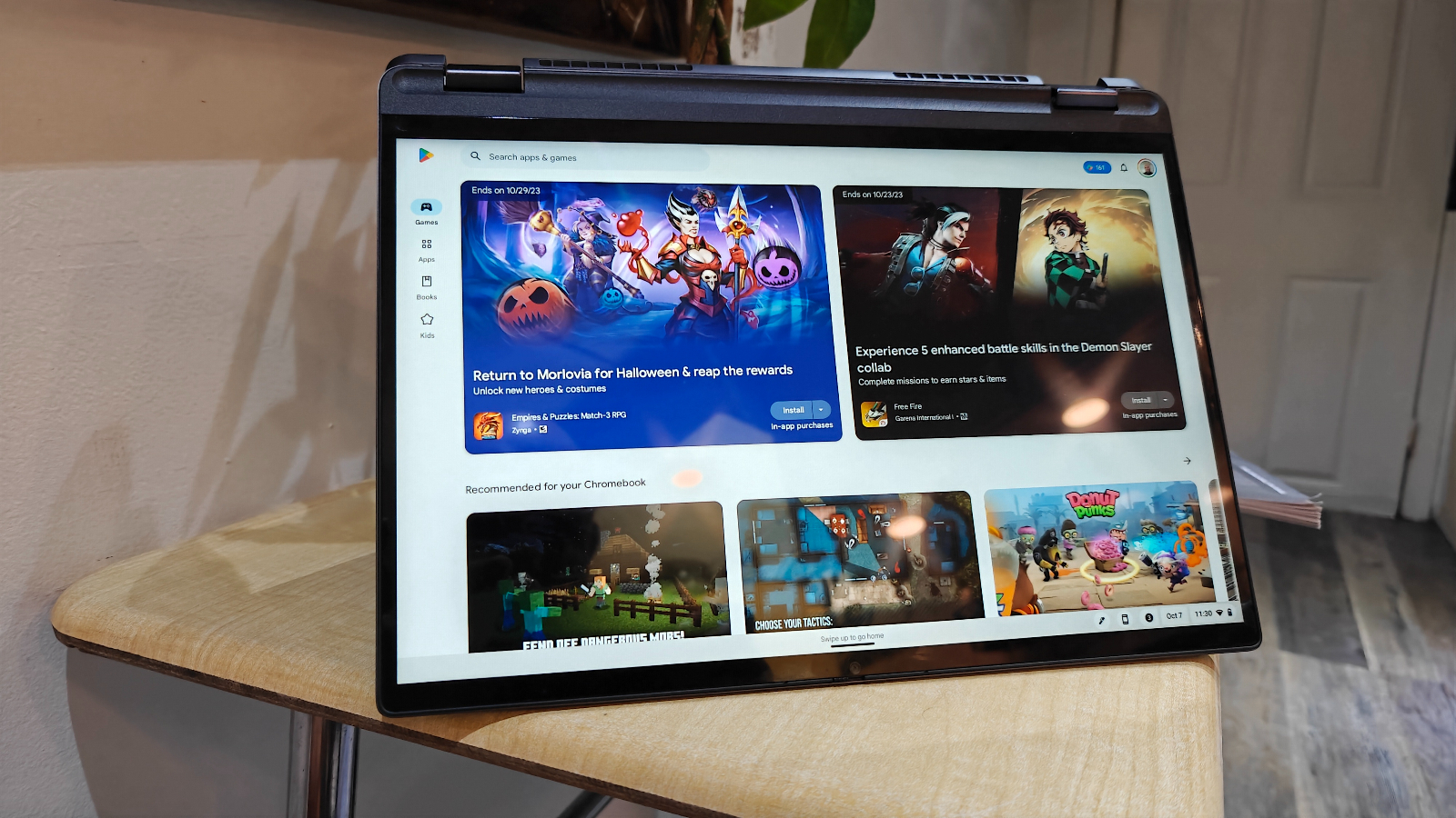Lenovo IdeaPad Flex 5i Chromebook Plus open in "tent mode" on a wooden desk.