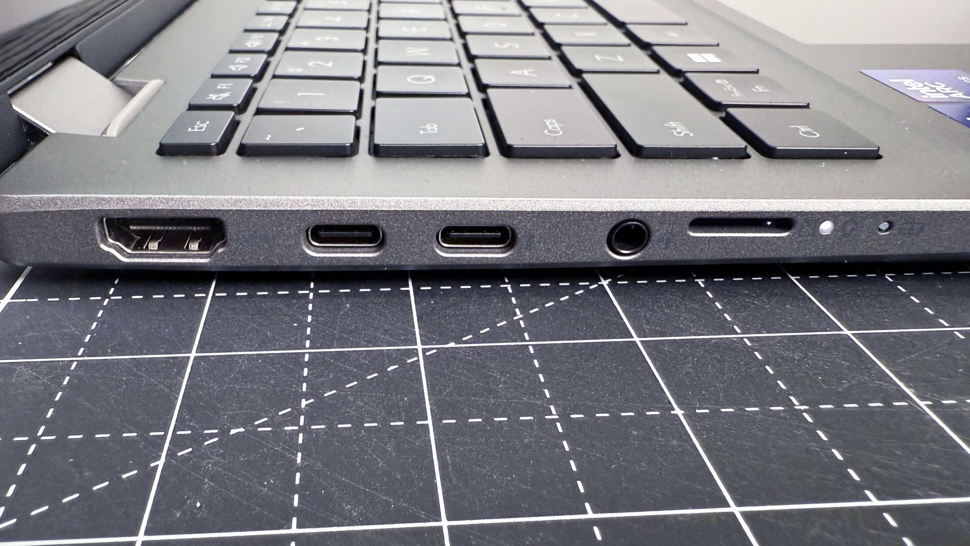 A close-up of the right-hand ports Asus Vivobook 16 Flip convertible laptop against a black and white desk.