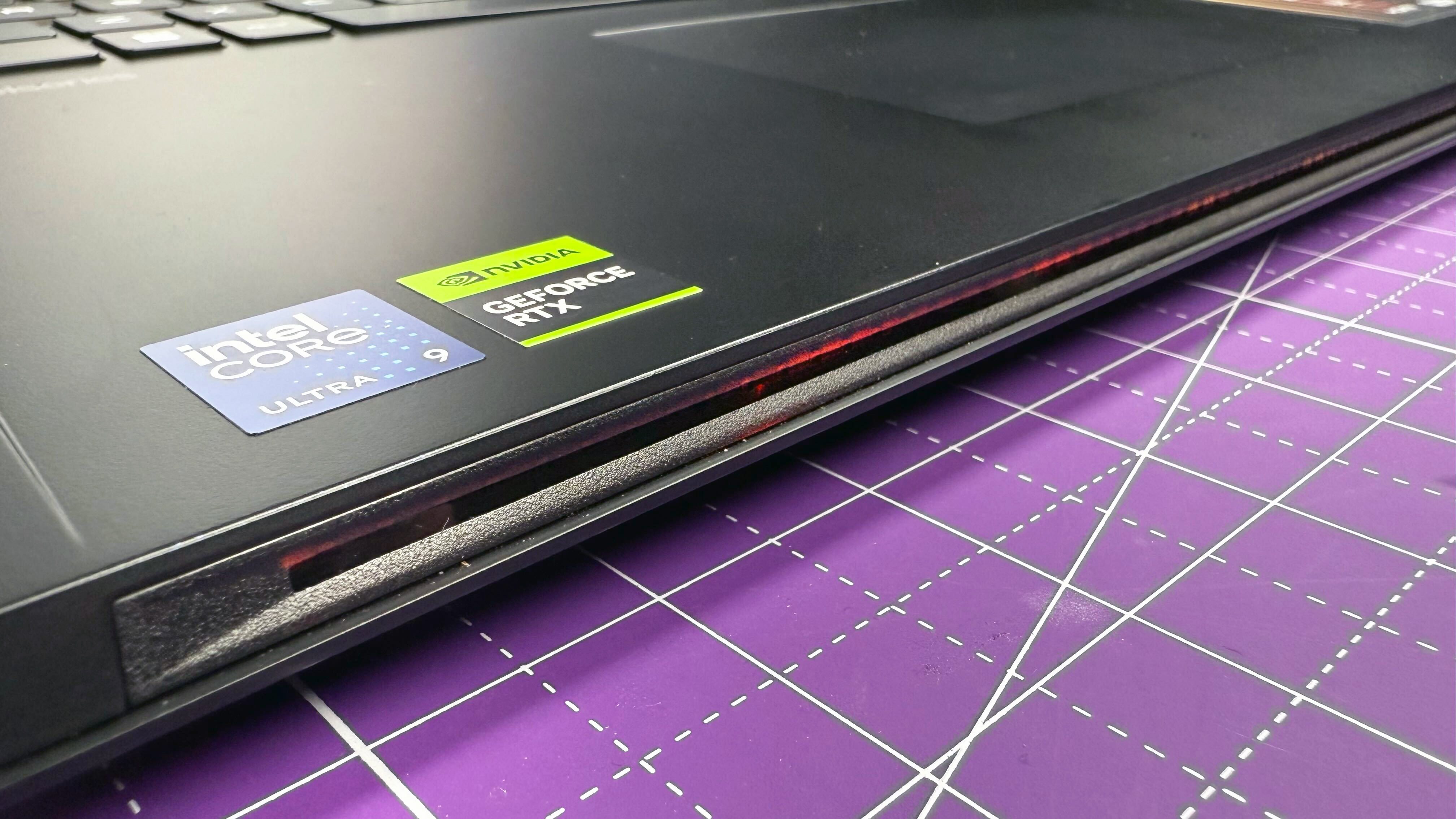 Close up of the RBG light strip on the MSI Raider 18 HX AI gaming laptop, against a purple mat.